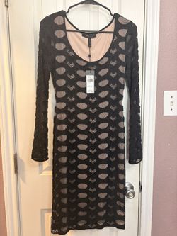 BCBG black lace bodycon dress with long sleeves and cutout details. Size: XS 