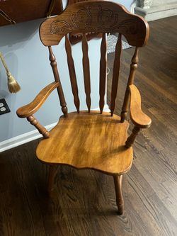Elegant wooden armchair with carved backrest.
