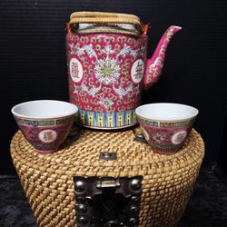 vintage Chinese tea set tucked inside a colorful, fabric-lined wicker picnic basket. 