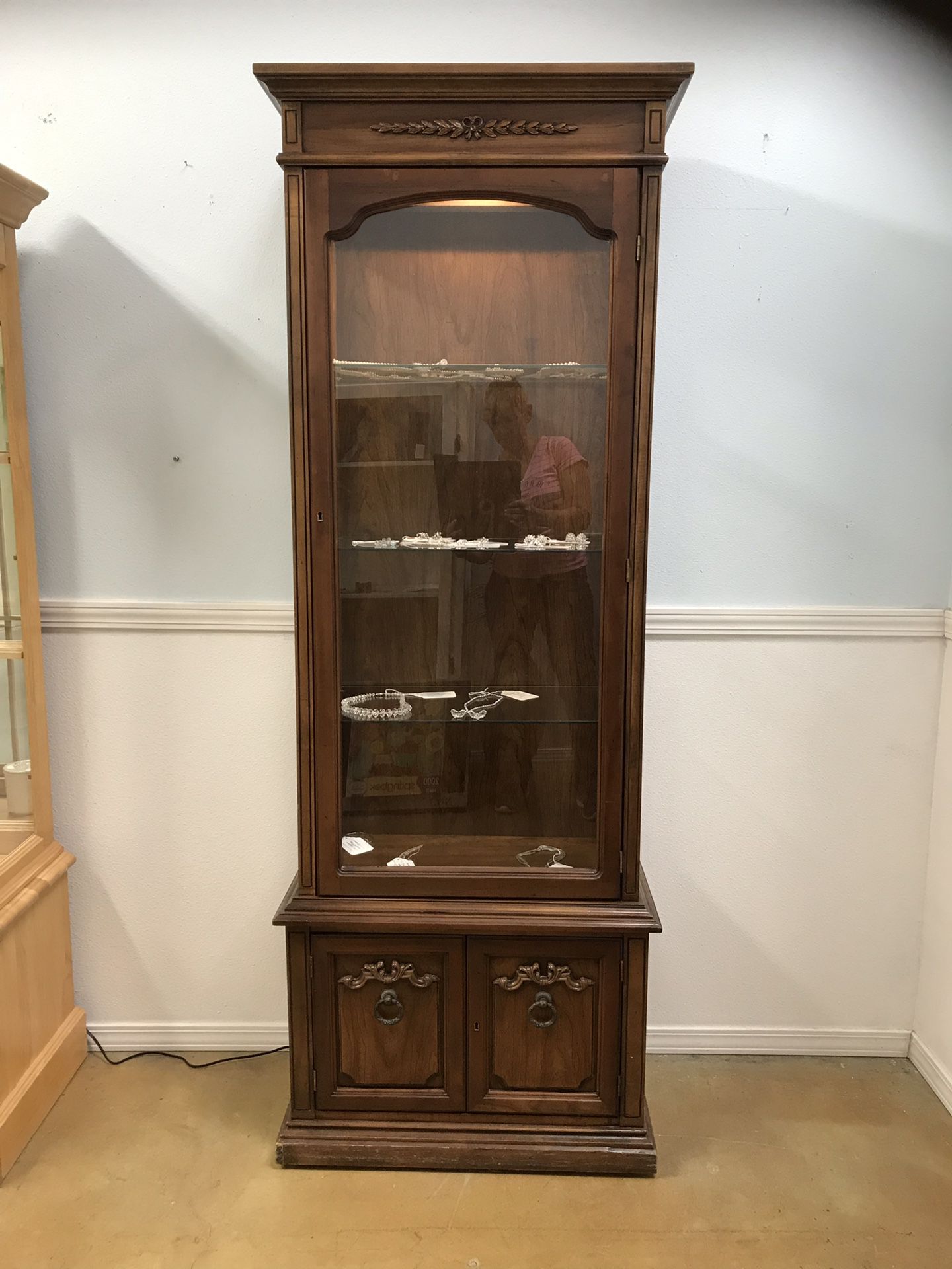 Lockable curio cabinet with storage and key.