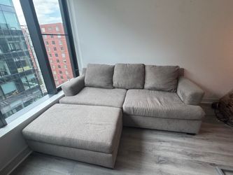 modern gray fabric couch with matching oversized ottoman.