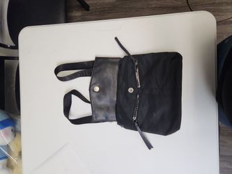 Botkier New York Trigger Mini Nylon Backpack. It is a versatile bag featuring a nylon body with a pebbled leather flap, dual front angled zipper pocke