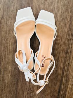 white ankle strap sandals featuring a low, block heel