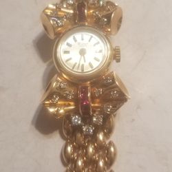 14K gold diamonds and Ruby Geneva Watch The 14K gold ban is attached to the watch work perfectly very good condition use