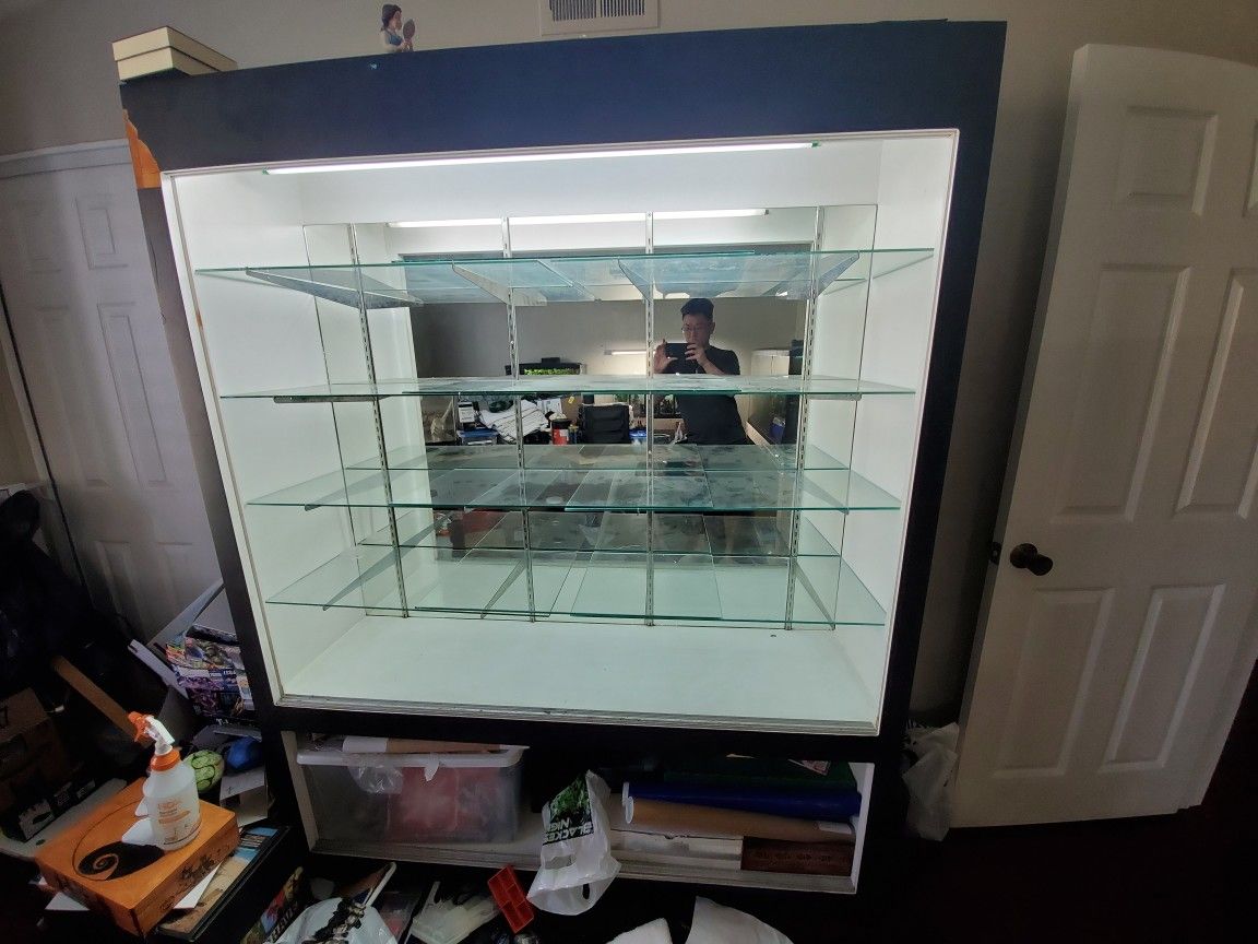 Toy collectible display case with glass shelves, sliding glass doors, and shelf racks