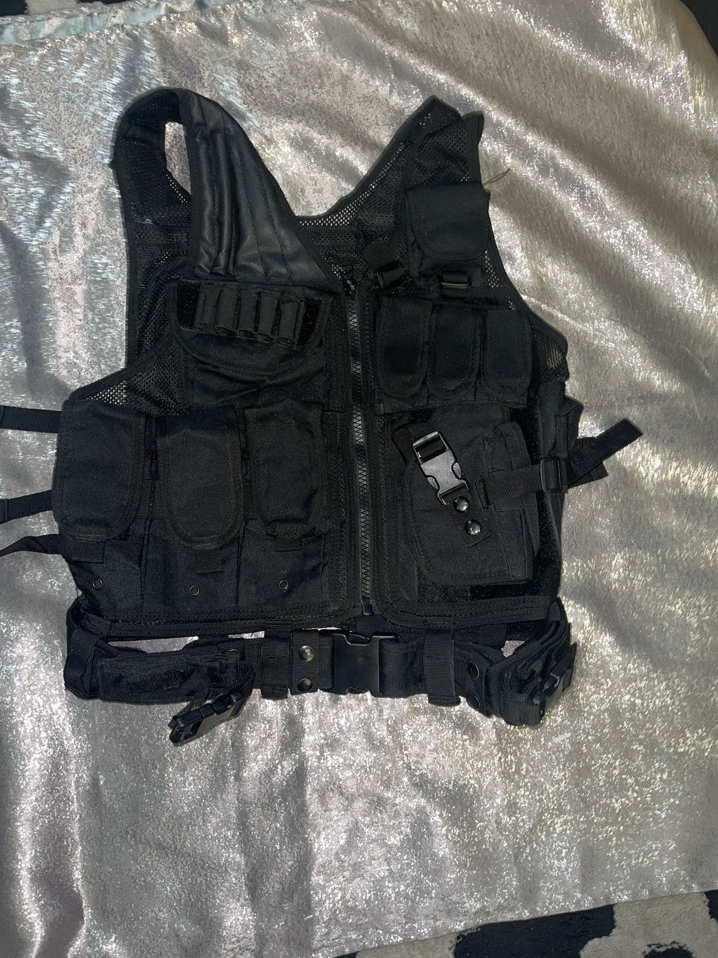 black tactical vest. It is designed for tactical and outdoor use, often seen in activities like airsoft, paintball, hunting, or training. These vests