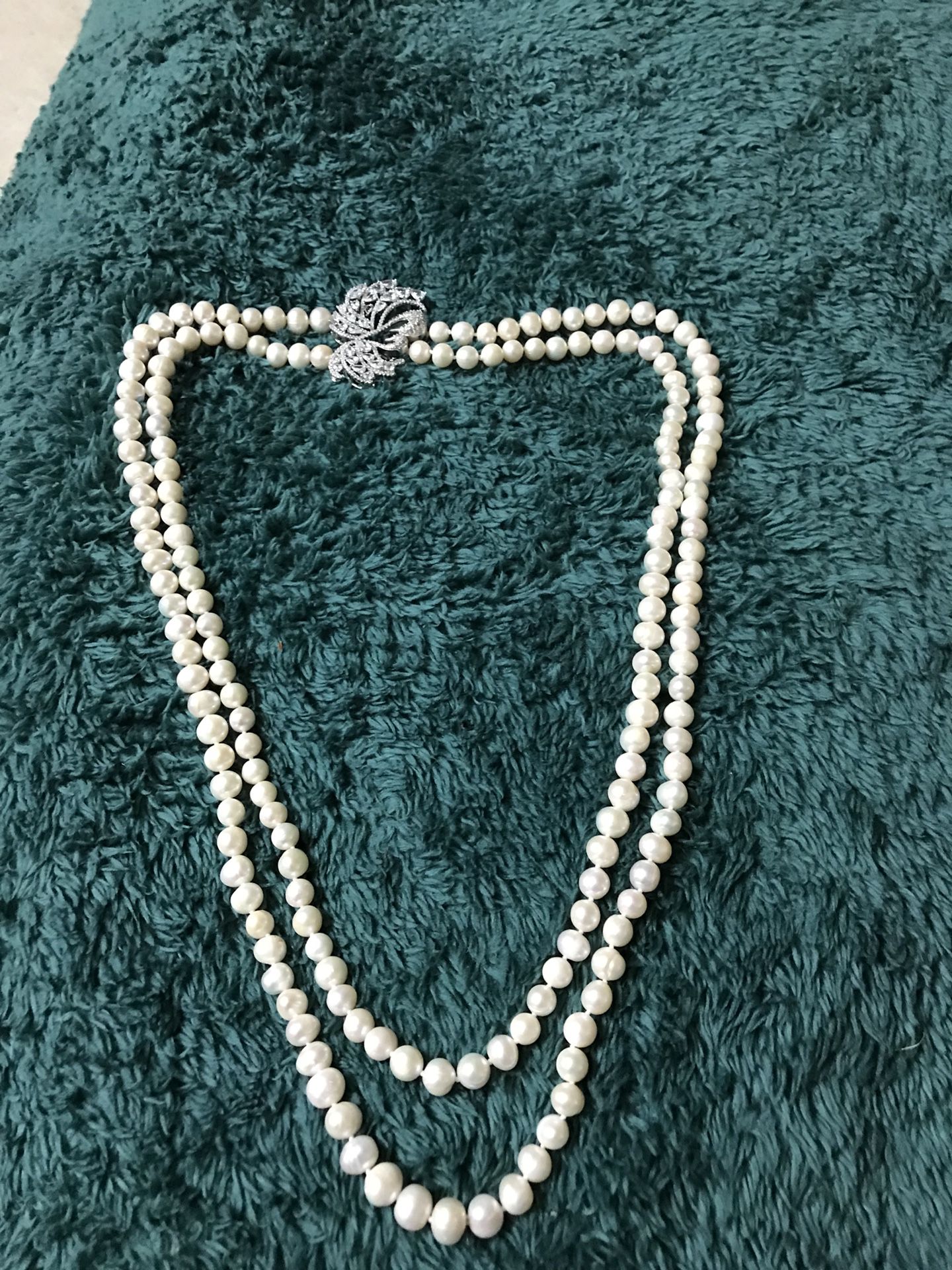 Long 2 layered pearl necklace with side broach