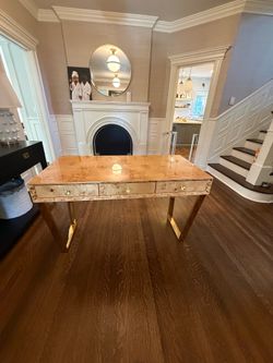 high-gloss burl wood writing desk with brass-finished legs and hardware