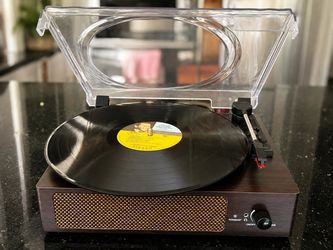 vintage style record player with a dark wood finish and built in stereo speakers.