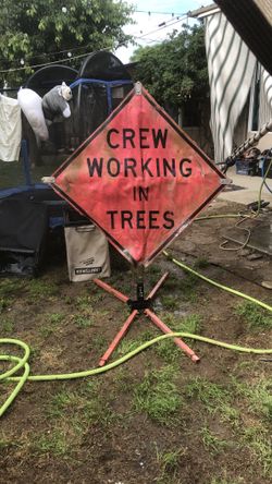 Crew working in trees, metal and canvas sign