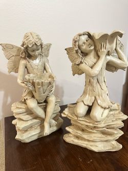 These are a set of ivory-white, hand-painted fairy garden sculptures made of designer resin, featuring detailed wings and a stone base.