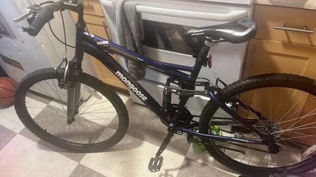 This appears to be a dark-colored Mongoose Ledge 2.1 Mountain Bike featuring a dual-suspension frame.