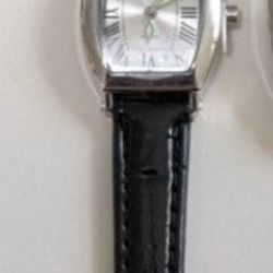 New  stylish watch with black leather strap and silver dials. 
It still has the protective cover on the face and the stem.