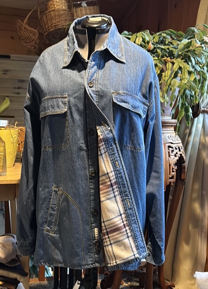 This lightweight denim jacket showcases a classic blue color and a traditional trucker style. It features a shirt-style collar and a comfortable fit,