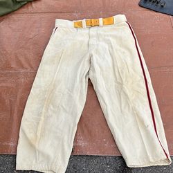 pair of vintage cream-colored baseball pants with red side stripes, identified as a collectible item dating from approximately the 1940s or 1950s