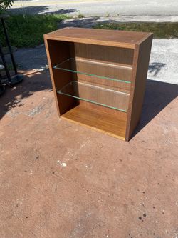 hanging display or storage cabinet with a warm wood finish and two removable glass shelves