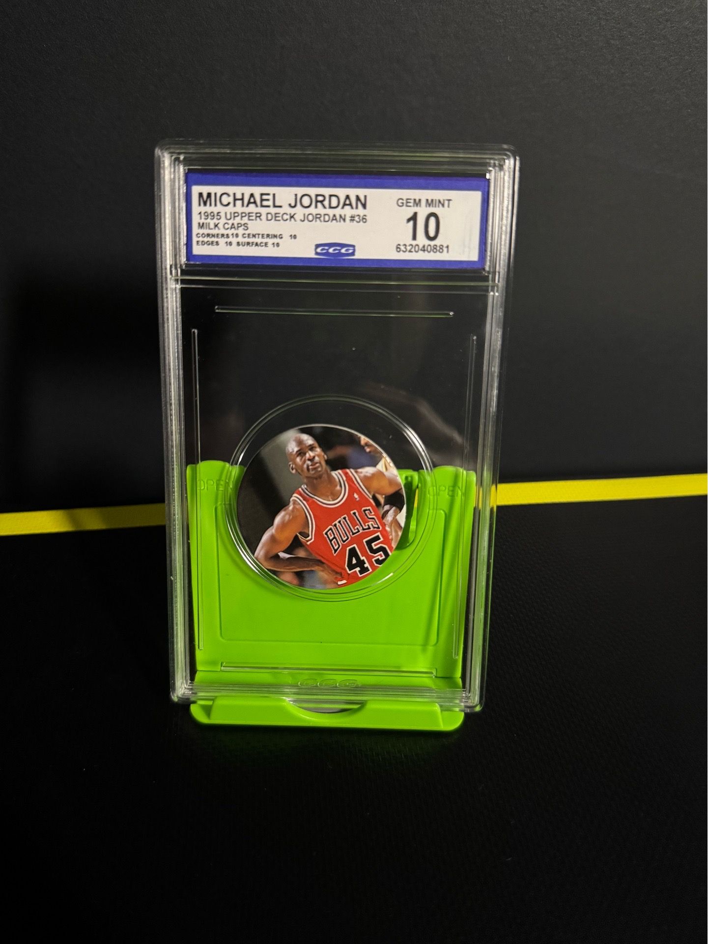 1995 Upper Deck Michael Jordan Milk Cap (Pog) #36. It is featuring Jordan wearing his famous comeback number 45 jersey. The grading company is CCG (