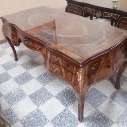 This desk is the epitome of craftsman ship because of its in laid wood and marquetry work. This piece also comes with glass on top. The glass itself i