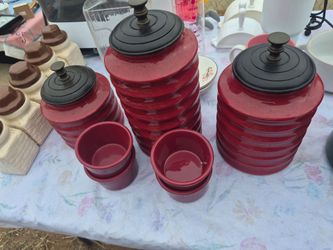 Pier 1 red speckled stoneware canisters with black ribbed lids.