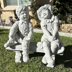 New Kids Sitting On Bench Made Out Of Cement 