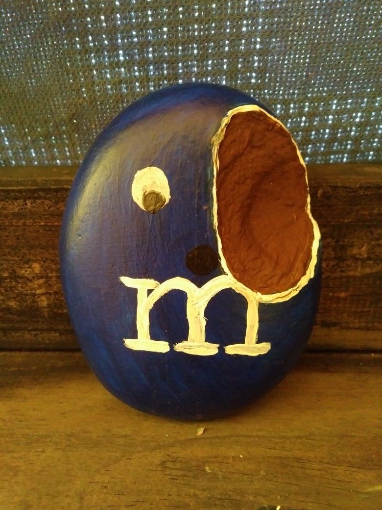 Rock painting like a m&m with a bite taken out of him
