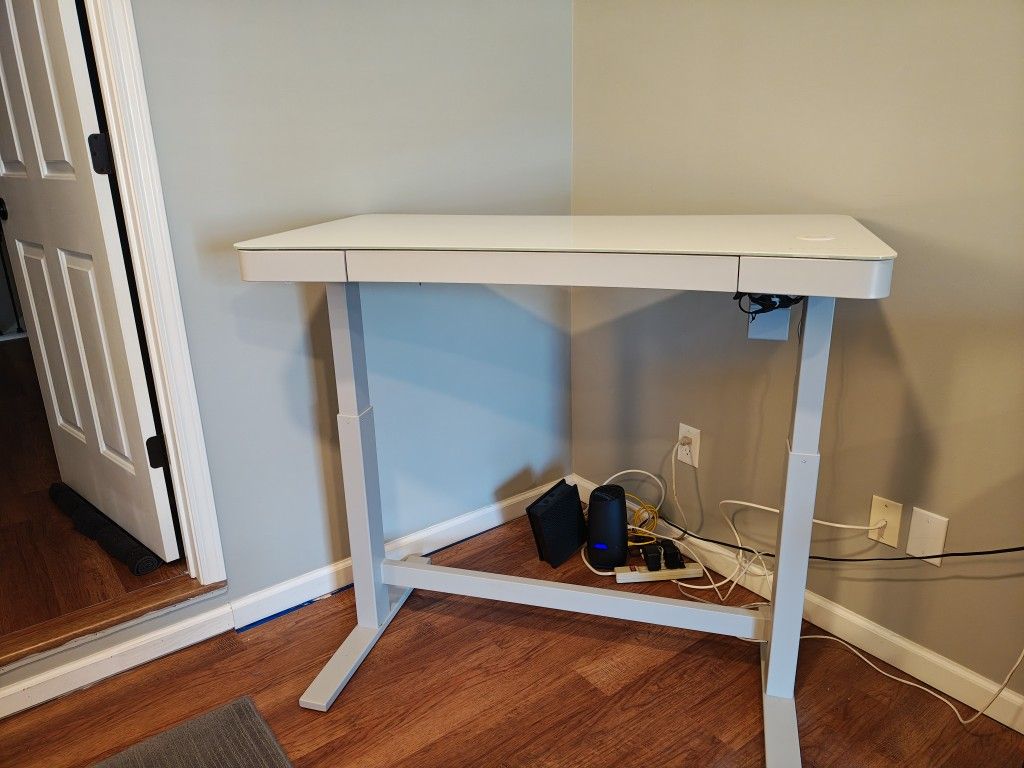 Contemporary height adjustable glass top desk with lots of features in excellent condition.