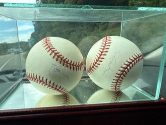 Randy Johnson and Roger Clemens signed baseballs with  glass case