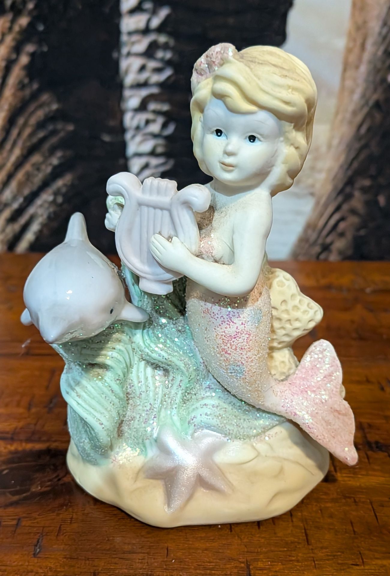 Mermaid figurine with dolphin.