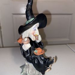 damaged witch eating doughnut figurine