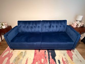 Full size blue velvet futon bed with area rug