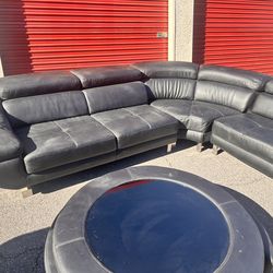 This is a black faux leather sectional sofa with adjustable headrests