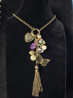 $10. Heart, butterfly, flower, ceramic bead, charm bronze colored tassel necklace, 26 inches long. Charm portion is 6 in long.