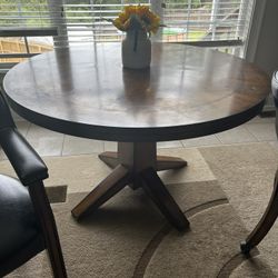 Wooden round dining room table with two chairs available