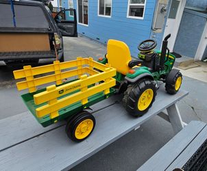 Kids John Deere Ground Force 12V Ride-On Tractor with Trailer, and it is manufactured by Peg Perego., Good condition, brand new charger, Normal wear