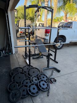 Bench press/squat rack with pulley system and 380lbs of Olympic weights and 7ft 45lbs bar and 6ft bar