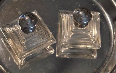 Irving Rice Art Deco stepped pyramid salt and pepper shakers made of clear glass with silver or chrome metal tops.
