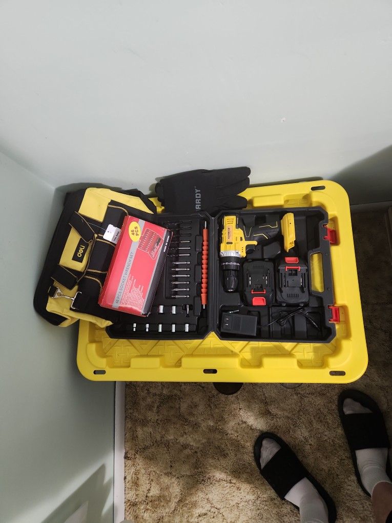 Drill Gun With All The Bit And Fits Also A Tool Bag And Gloves Along With A Socket Set