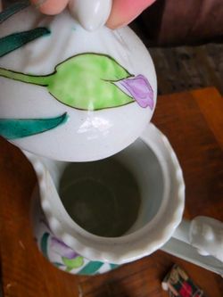 +4 This appears to be a vintage hand-painted ceramic pitcher