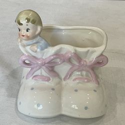 1959 Ruben's Originals ceramic planter of a baby in baby shoes.