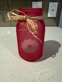 Pink vase with sunflower in front