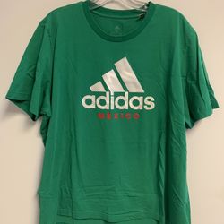 The Adidas Originals Mexico T-Shirt in Men's Size XL is a green short sleeve shirt made of cotton with a graphic print of the Adidas Trefoil logo. It 