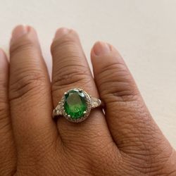 Silver Ring With Emerald Center Piece Surrounded By Sparkling White Gemstones
