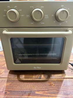 Beige Our Place Wonder Oven is a multi-functional countertop appliance. This toaster oven and air fryer has three control knobs on the front panel for
