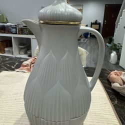 White pitcher with gold accents, perfect for serving beverages.
