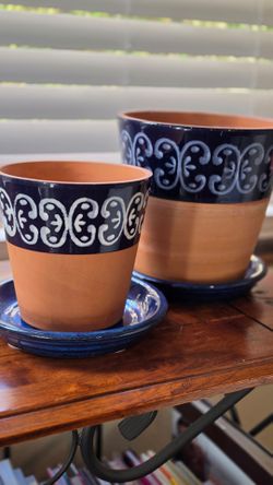 Two hand painted terracotta plant pots w/matching saucers