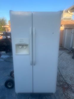 Side by side white refrigerator with ice maker.