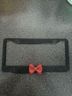 License plate metal cover, black rhinestones and red bow, in great condition , no holds