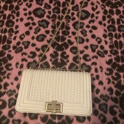 white bag with gold shoulder strap