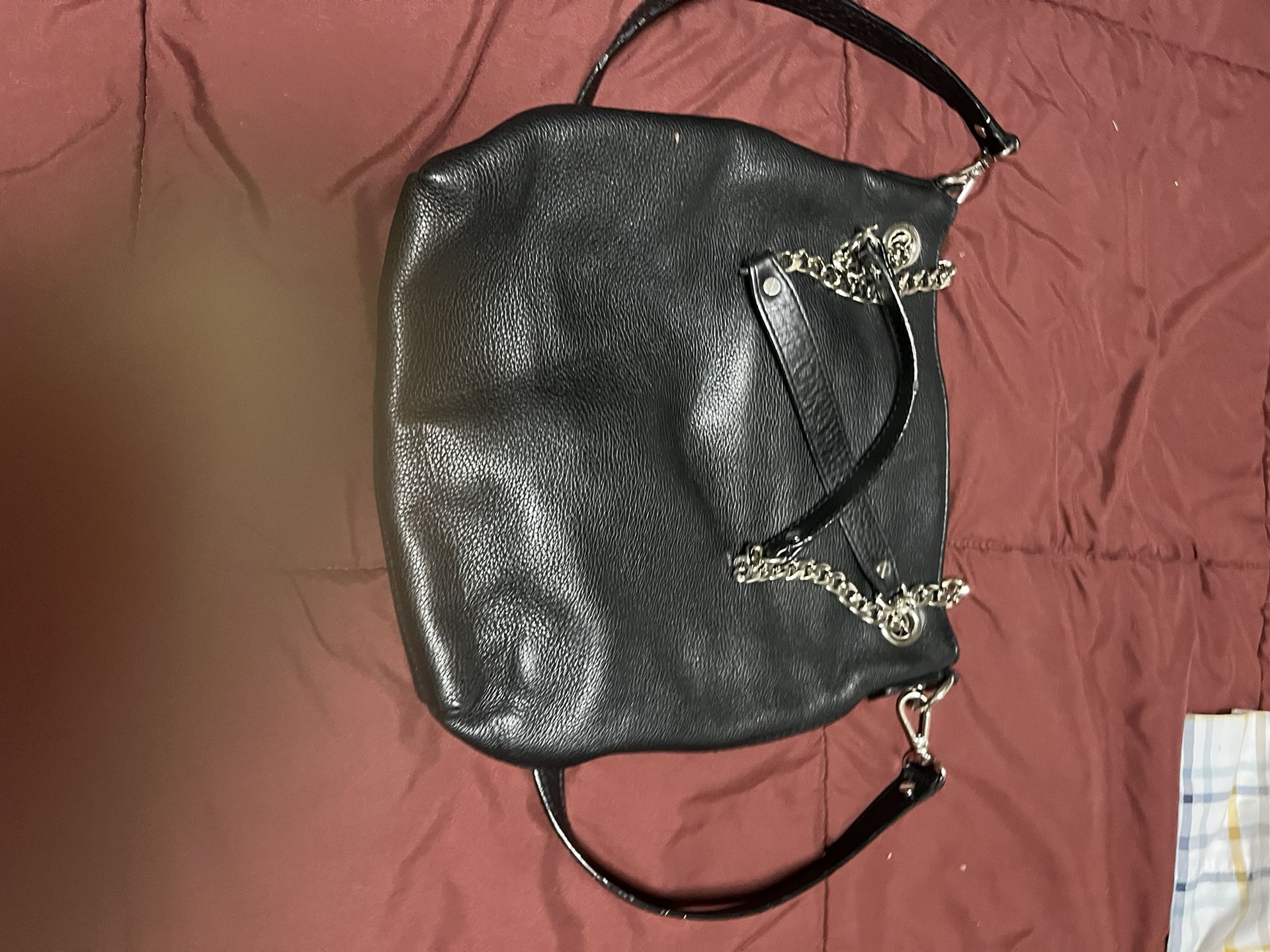 Coach Stylish black leather handbag with chain straps.