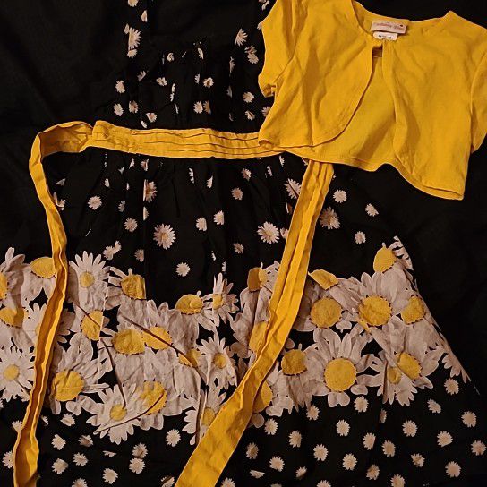 Girls black & white daisy dress size 7 by Ashley Ann. Comes with a yellow vest and a large bow in the rear. 65% poly, 35% cotton.